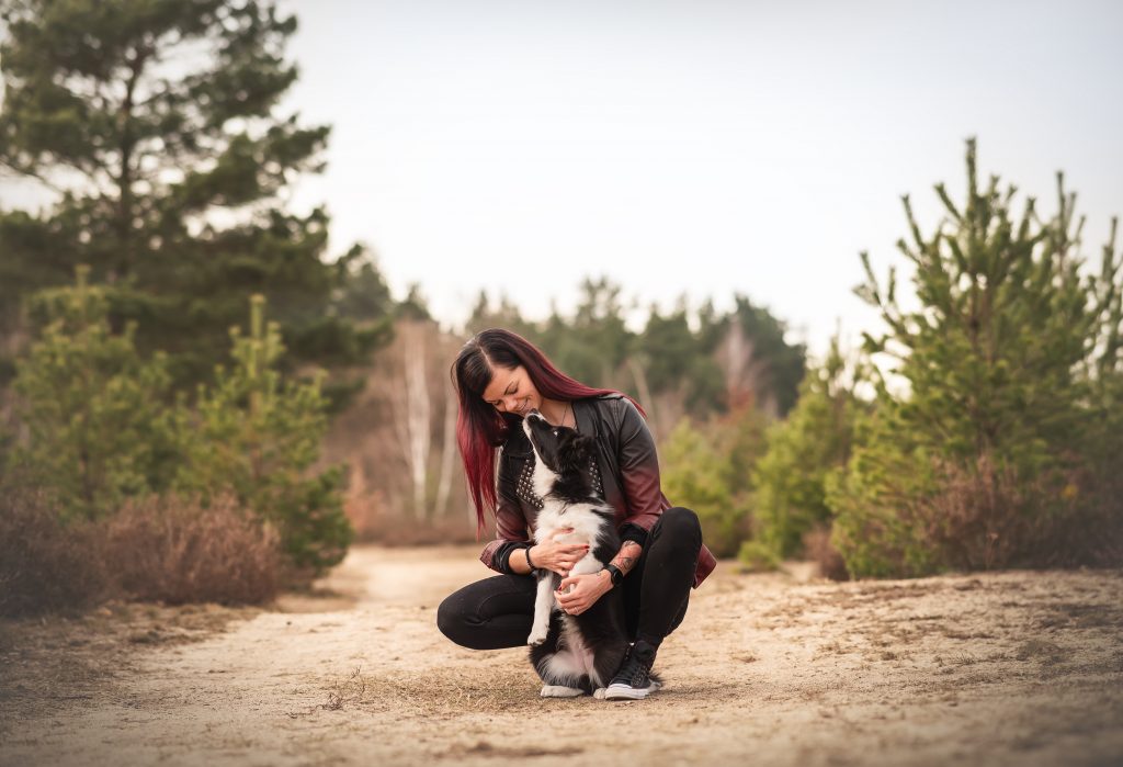 Das Bild zeigt einen Welpen, der einer jungen Frau einen Kuss gibt